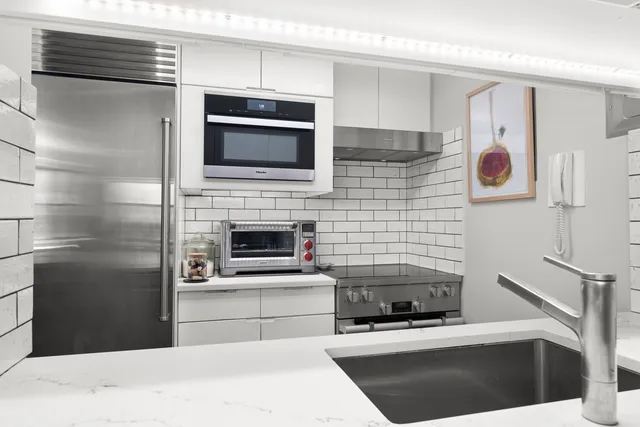 a kitchen with stainless steel appliances kitchen island a stove and a microwave