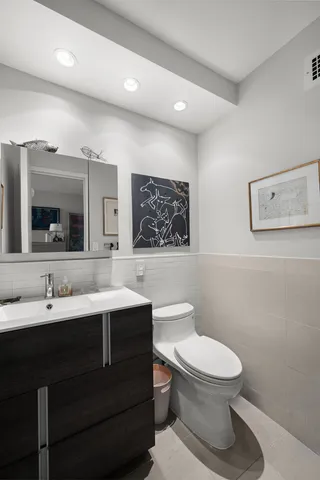 a bathroom with a toilet sink and mirror
