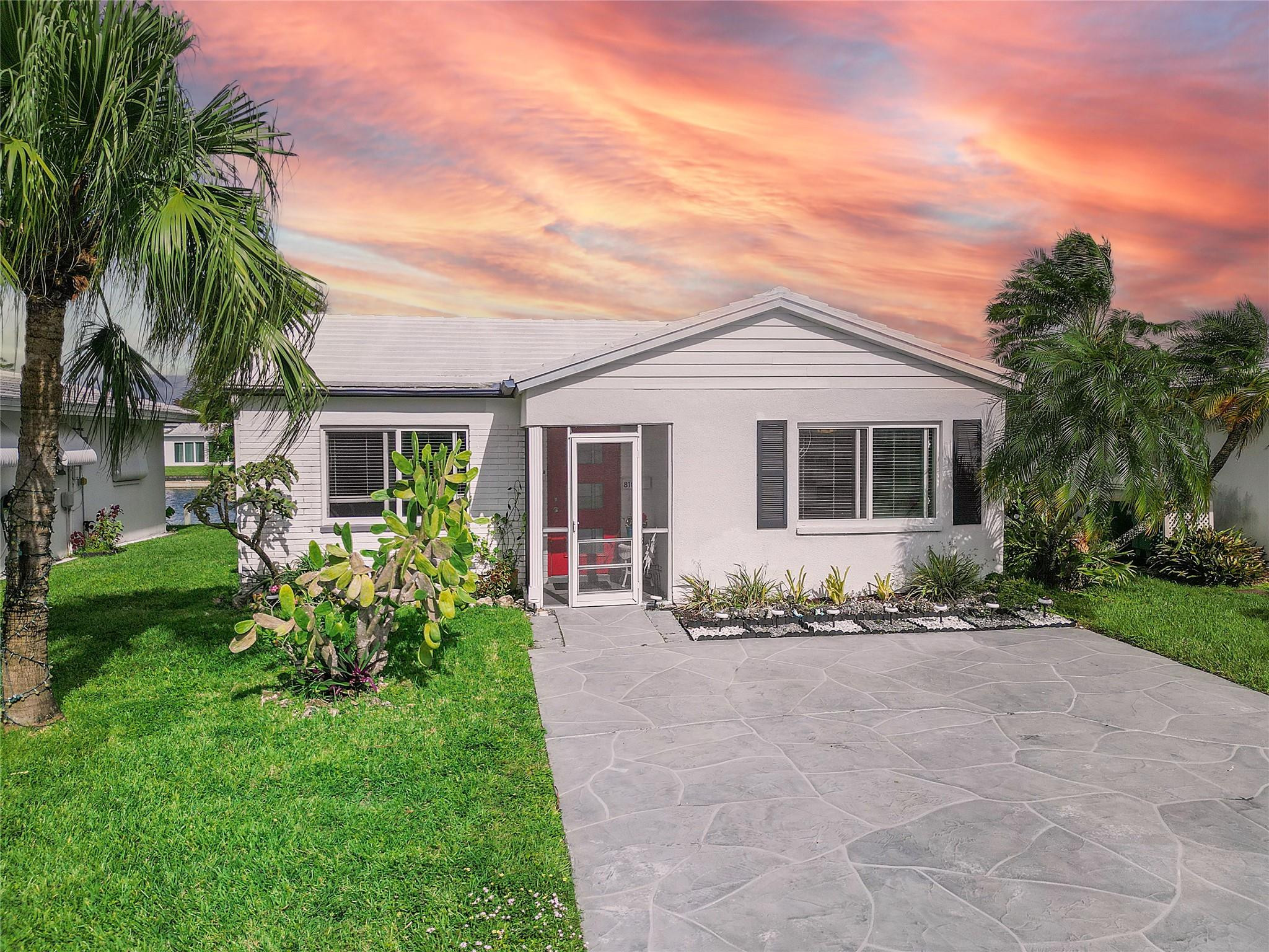 8103 Northwest 58th Place Tamarac, FL 33321 - Photo 1 of 19 a front view of a house with a garden and yard