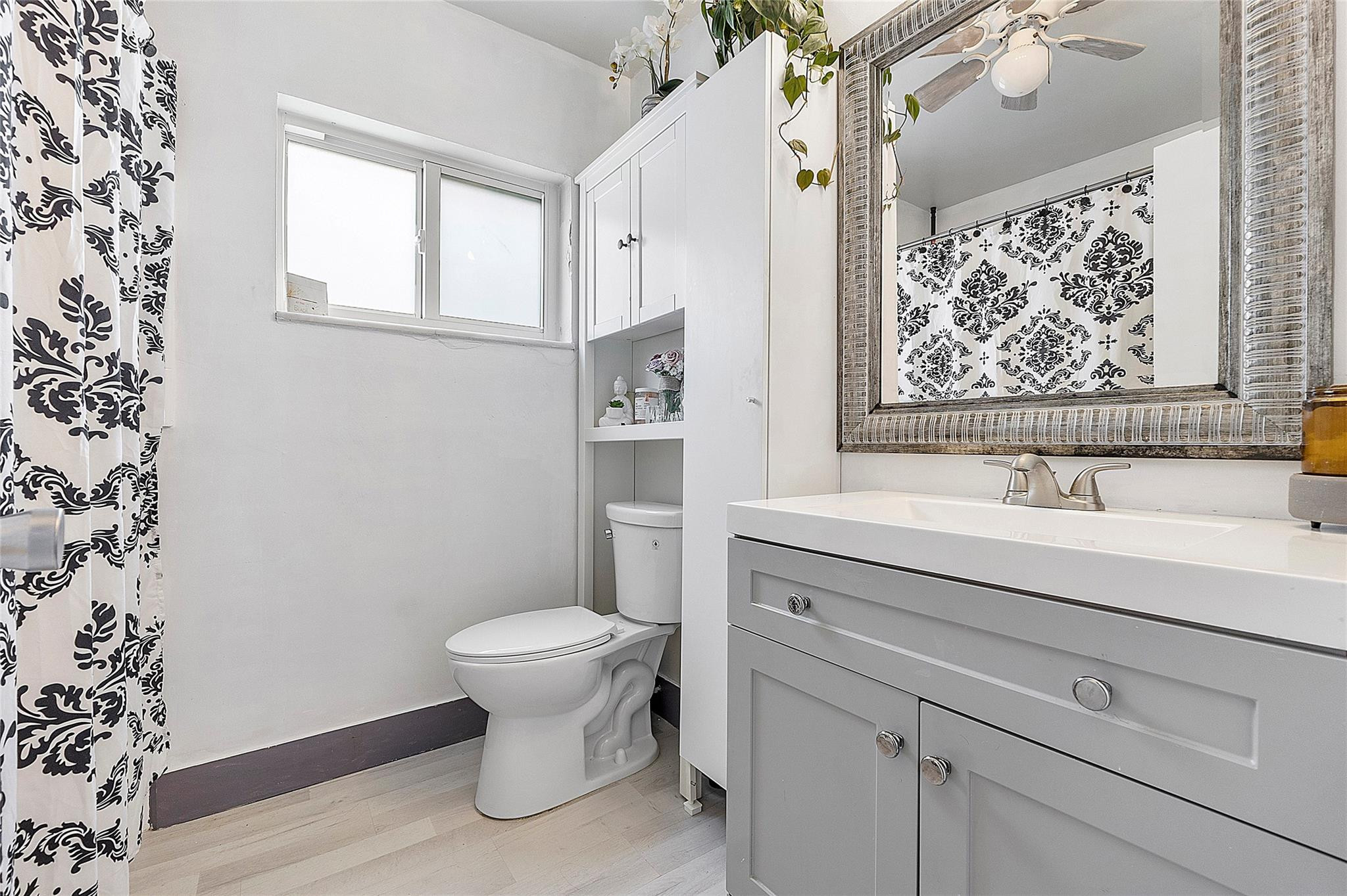 8103 Northwest 58th Place Tamarac, FL 33321 - Photo 13 of 19 a bathroom with a sink toilet and window