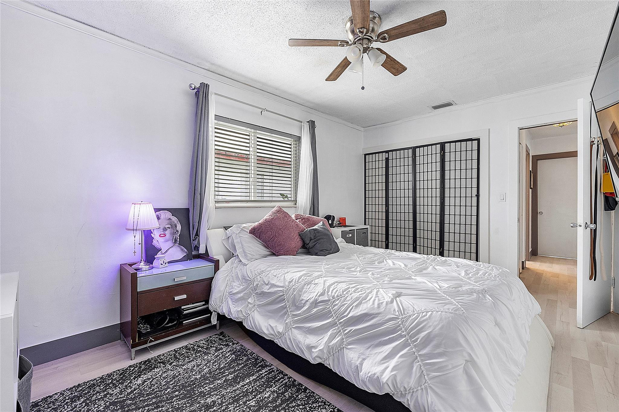 8103 Northwest 58th Place Tamarac, FL 33321 - Photo 15 of 19 a bedroom with a bed and wooden floor
