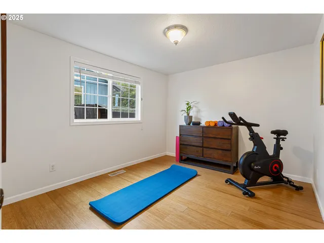 a living room with furniture and a gym machine