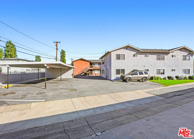 a view of a white house with a yard and sitting area