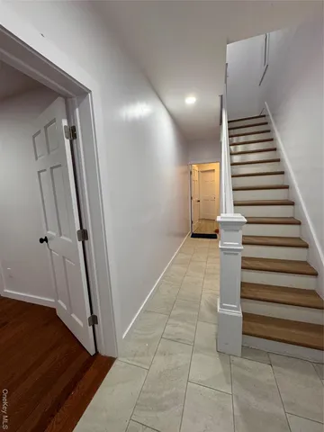 a view of a hallway with entryway and stairs