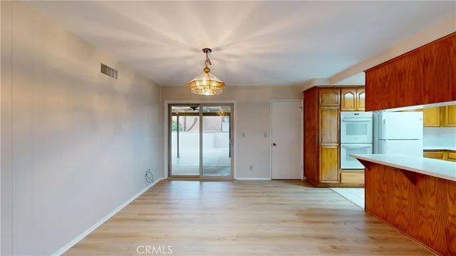 a view of a kitchen with a fridge and wooden floor