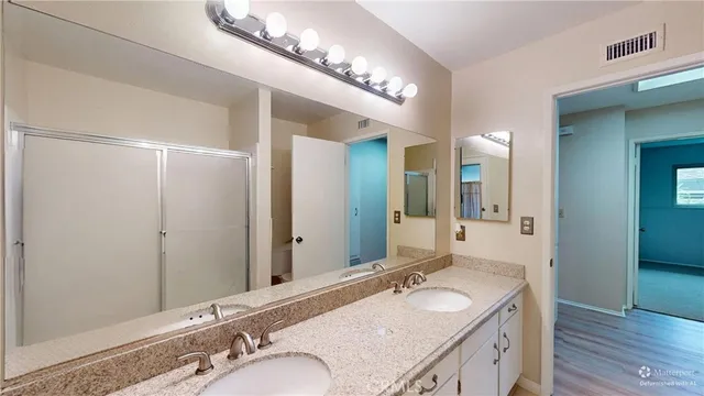 a bathroom with a granite countertop sink and a mirror