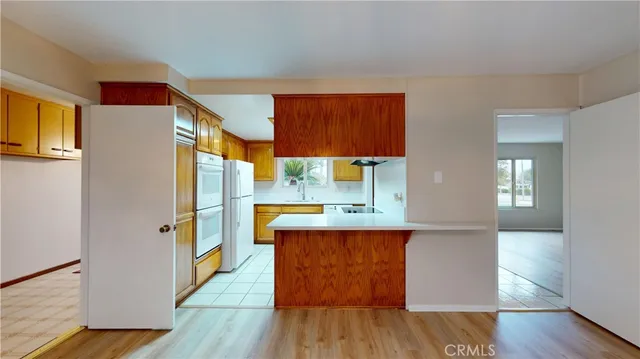 a kitchen with stainless steel appliances a refrigerator and a wooden floor