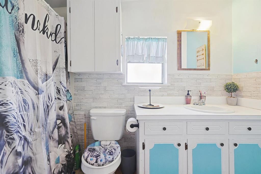 491 Emily Lane Van Alstyne, TX 75495 - Photo 18 of 21 a bathroom with a sink a toilet and a mirror