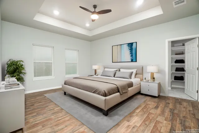 a spacious bedroom with a large bed and a chandelier