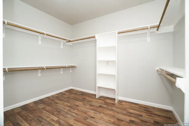 a view of walk in closet with empty racks