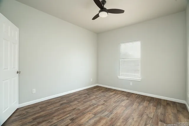 wooden floor in an empty room with a window
