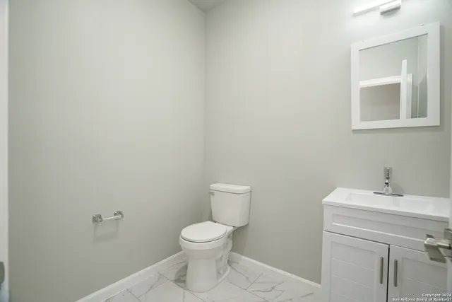 a white toilet sitting next to a bathroom sink
