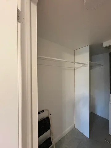 a view of an empty room and chandelier fan