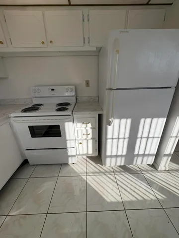 a kitchen with granite countertop a stove a sink and a refrigerator