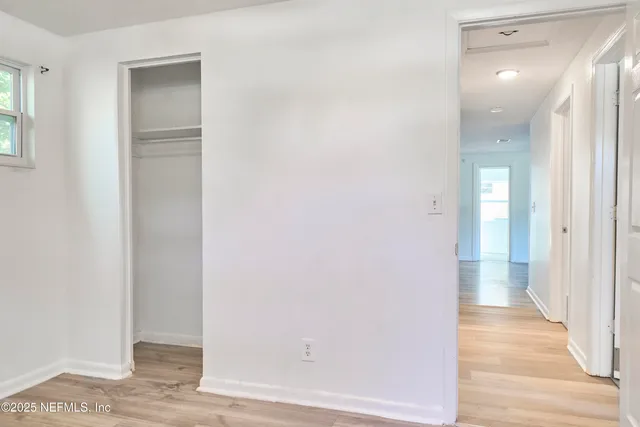 a view of a hallway with wooden floor