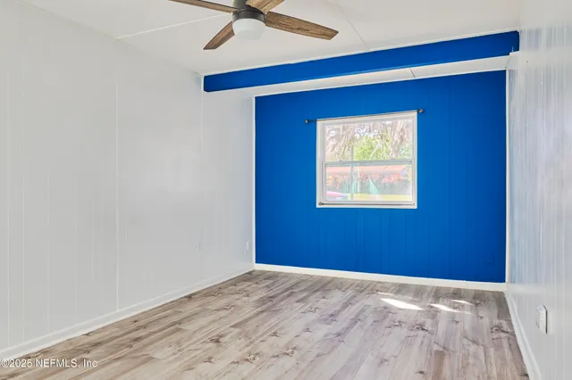 a view of empty room with a window and ceiling fan