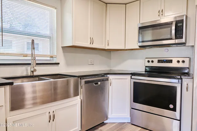 a kitchen with stainless steel appliances granite countertop a stove microwave and cabinets