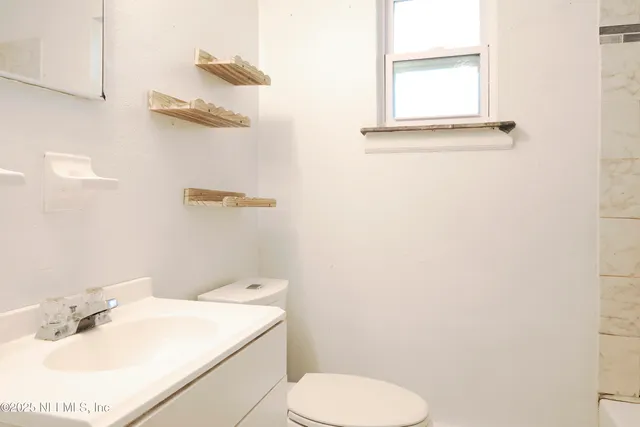 a bathroom with a sink mirror and toilet