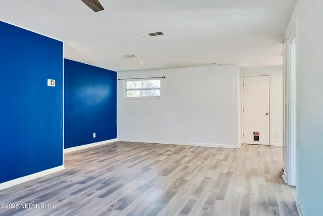 a view of empty room with wooden floor