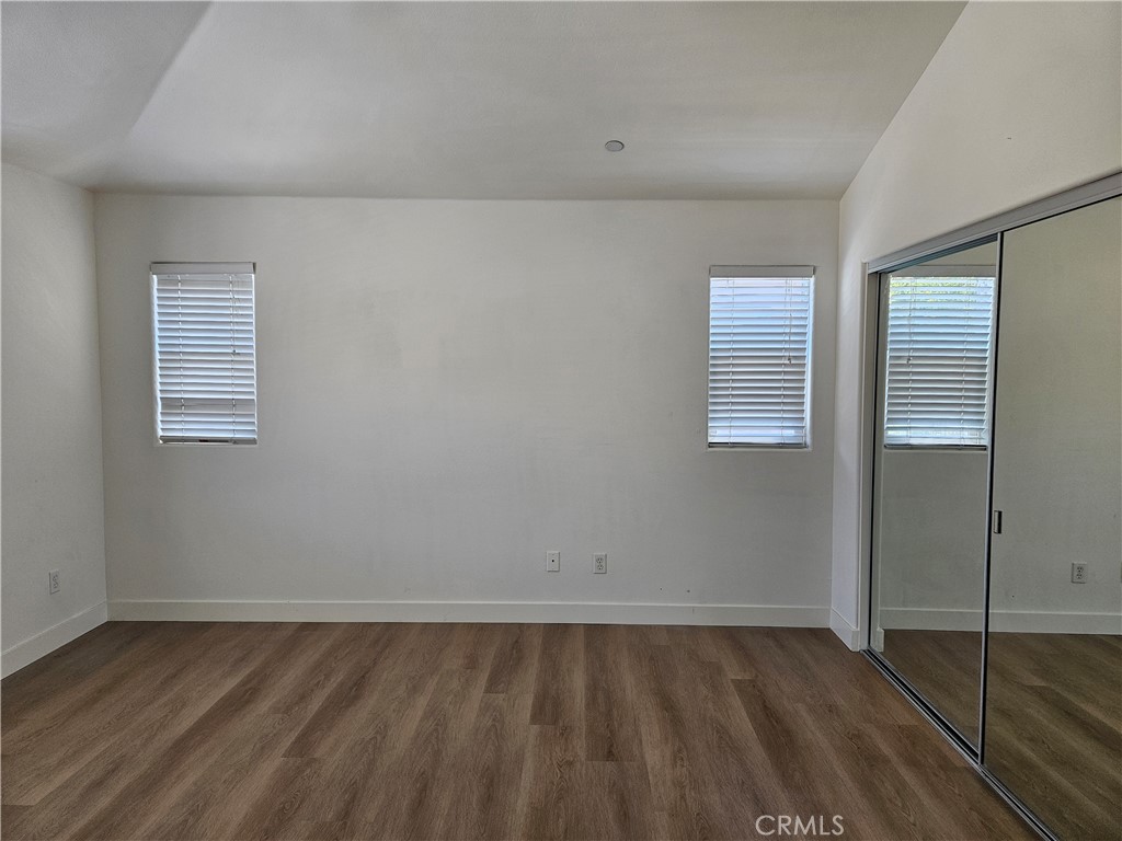 8598 Belmont Street Cypress, CA 90630 - Photo 15 of 23 an empty room with wooden floor and windows