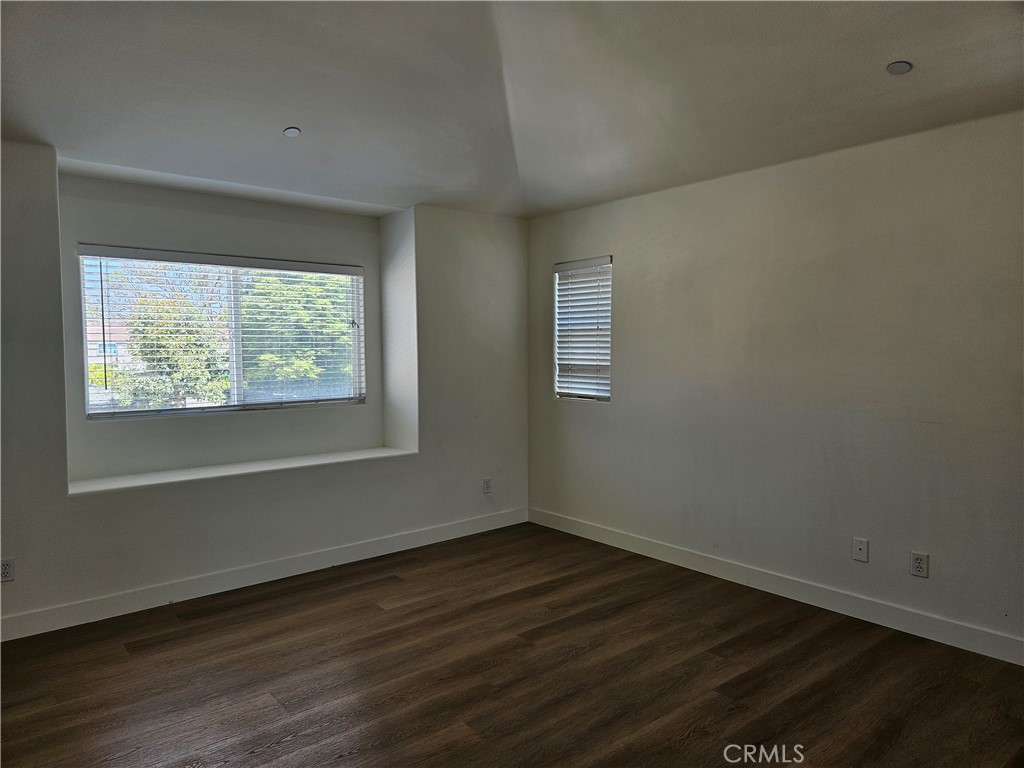 8598 Belmont Street Cypress, CA 90630 - Photo 16 of 23 a view of an empty room with wooden floor and a window