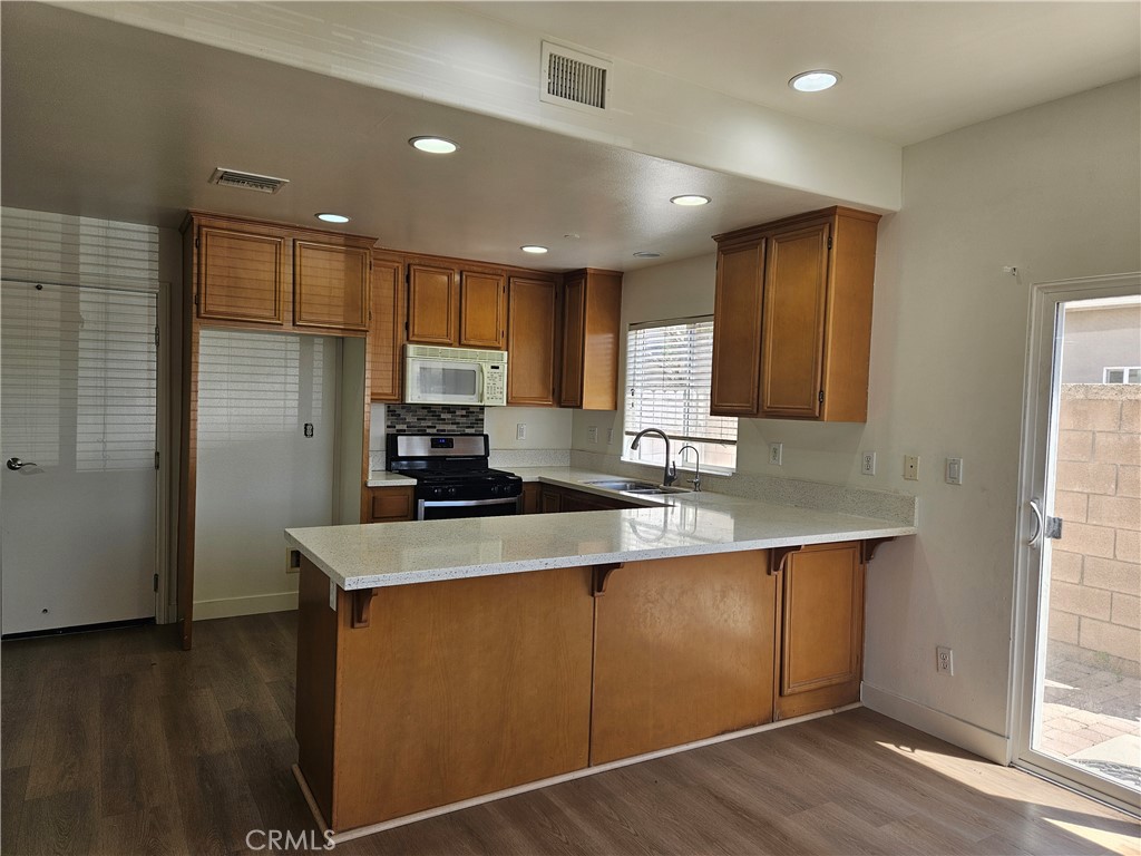 8598 Belmont Street Cypress, CA 90630 - Photo 8 of 23 a kitchen with stainless steel appliances granite countertop a sink a refrigerator and a stove