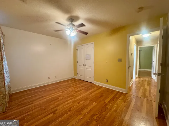 a view of an empty room with wooden floor