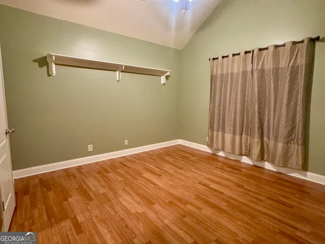 a view of a room with wooden floor and a window