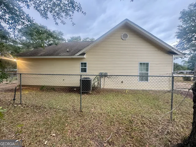 a view of a house with backyard and tree