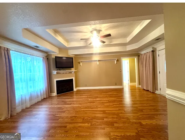 a view of an empty room with a fireplace and a window