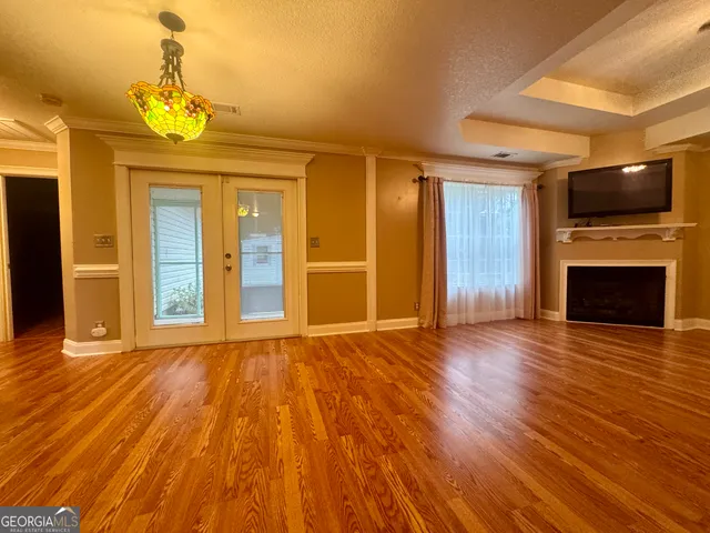 a view of a livingroom with wooden floor and a ceiling fan
