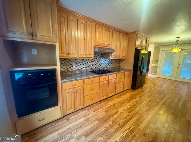 a kitchen with granite countertop wooden cabinets and stainless steel appliances