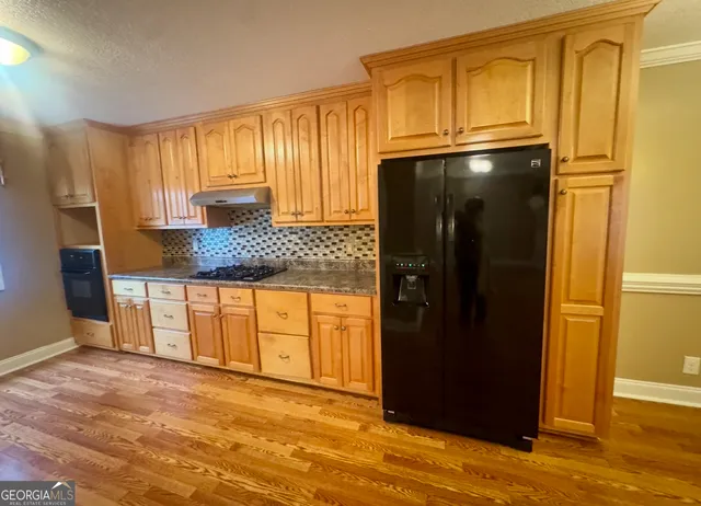 a kitchen with stainless steel appliances granite countertop a refrigerator and a granite counter tops