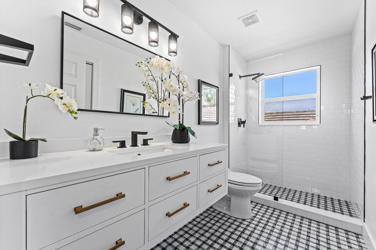 3395 Northwest 53rd Circle Boca Raton, FL 33496 - Photo 19 of 64 a bathroom with a sink a toilet and a mirror