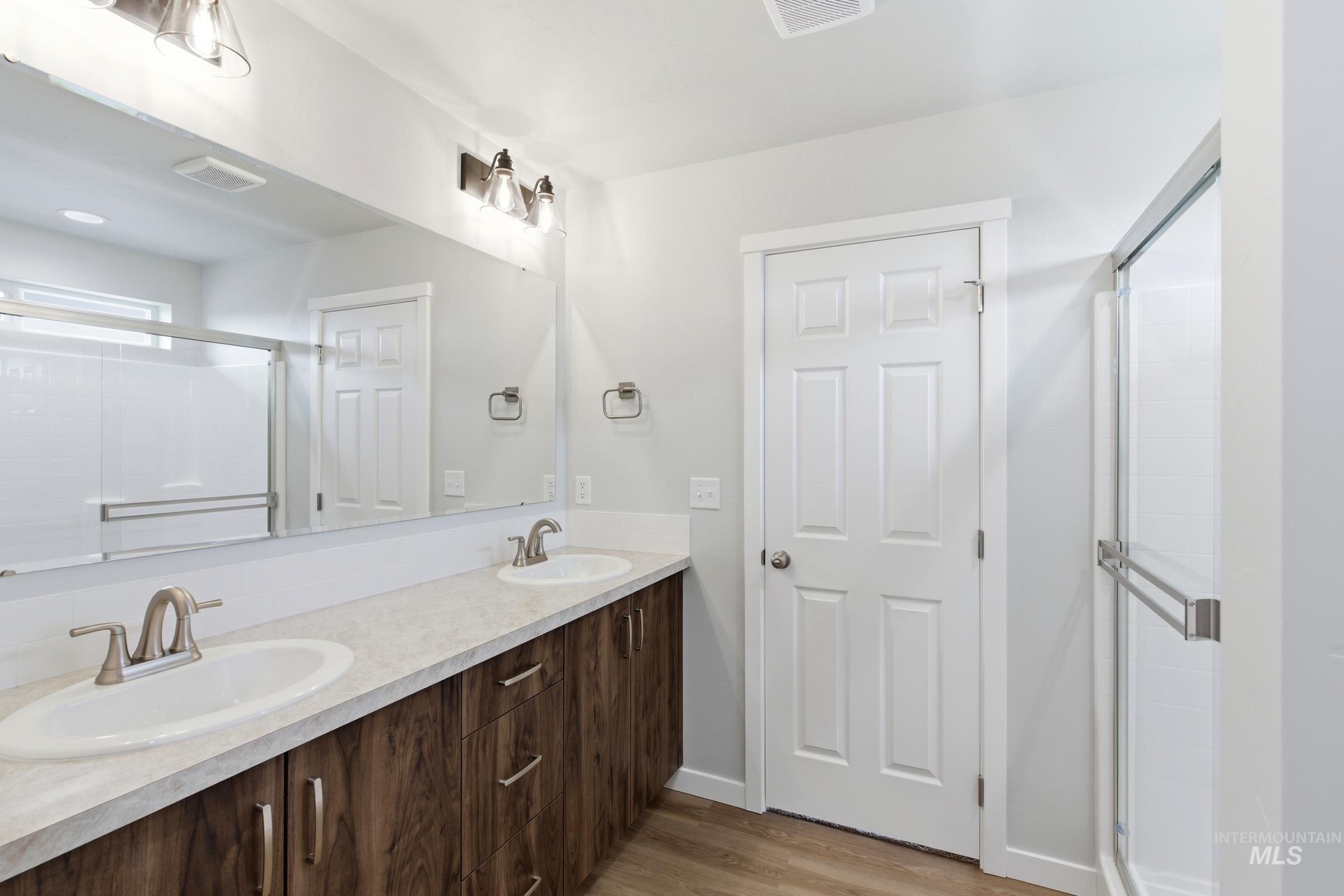 16558 Dunning Way Caldwell, ID 83607 - Photo 28 of 35 Double vanity with wood-finish cabinetry, light-toned countertop, and dual sinks