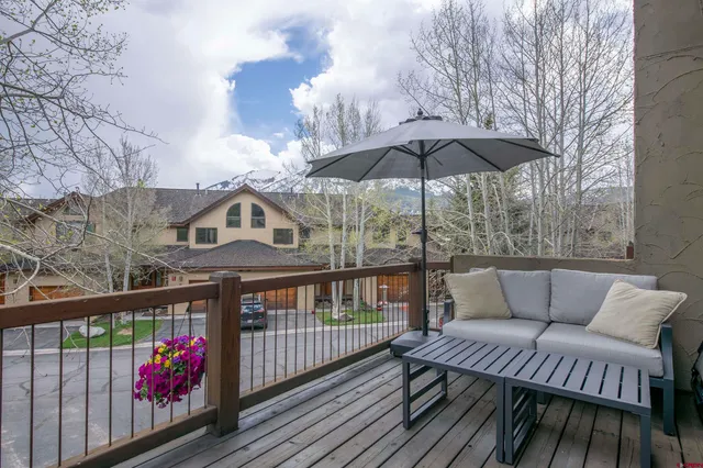 a view of a house with wooden deck and furniture
