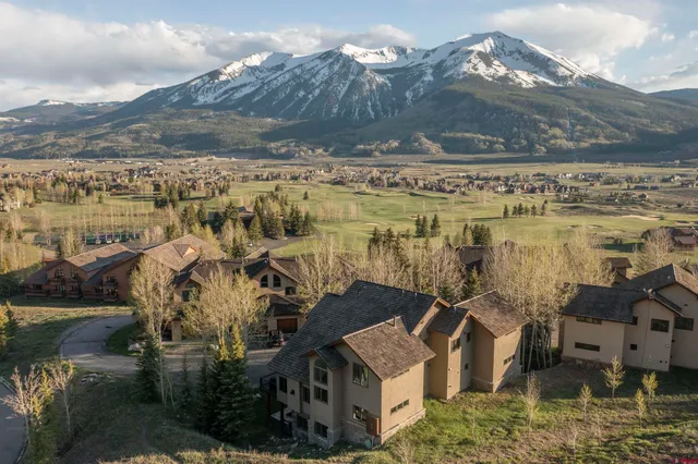 a view of a house with a yard and mountain in the background