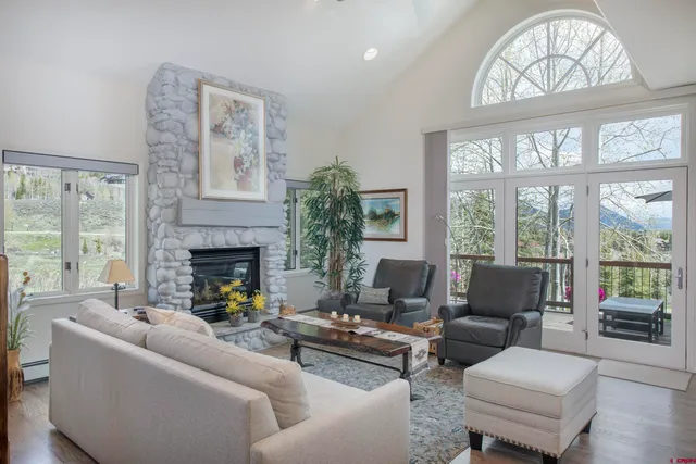 a living room with furniture fireplace and a large window