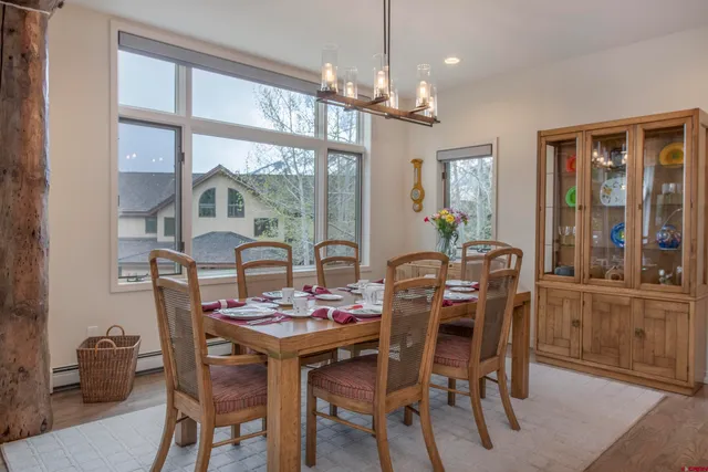 a dining room with furniture a chandelier and wooden floor
