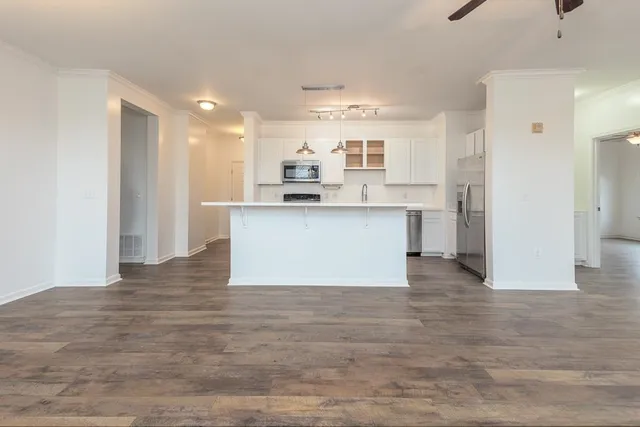 a view of kitchen with wooden floor and electronic appliances