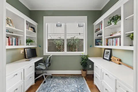 a view of a hallway with a chandelier fan and windows