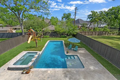 a view of a house with a swimming pool and sitting area