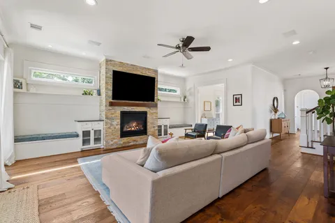 a kitchen with stainless steel appliances granite countertop a sink a stove a refrigerator cabinets and a dining table with wooden floor