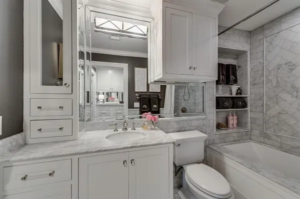 a bathroom with a granite countertop toilet sink and bathtub