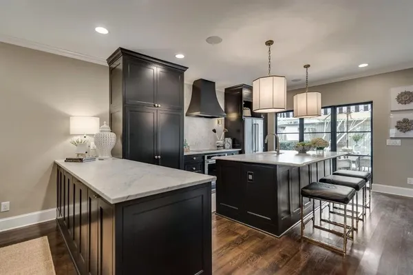 a kitchen with stainless steel appliances kitchen island granite countertop a sink a stove a dining table and chairs