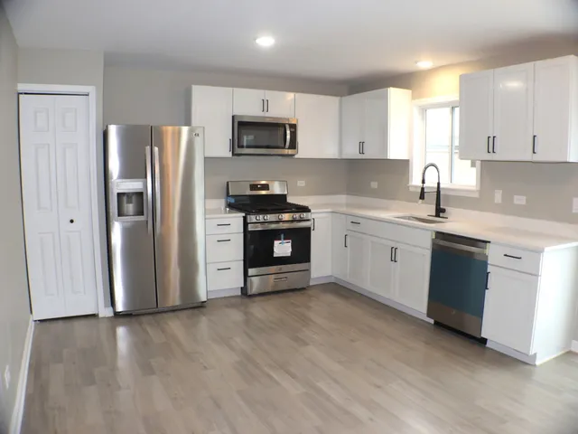 a kitchen with stainless steel appliances a sink cabinets and a refrigerator