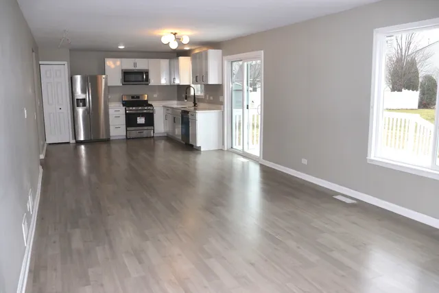 a view of kitchen with refrigerator stove and wooden floor