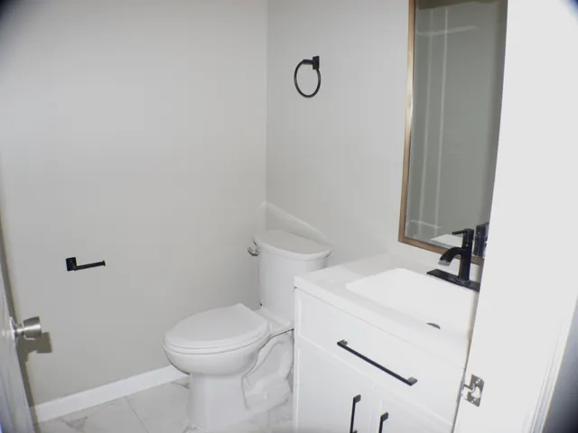 a bathroom with a sink a toilet and a mirror