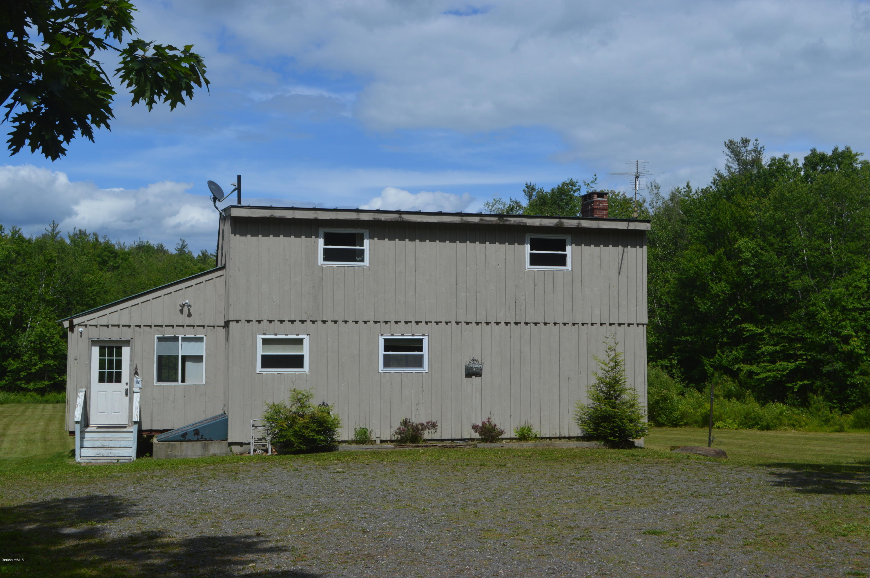 115 Webster Road Tyringham, MA 01264 - Photo 22 of 23 a front view of a house with a garden