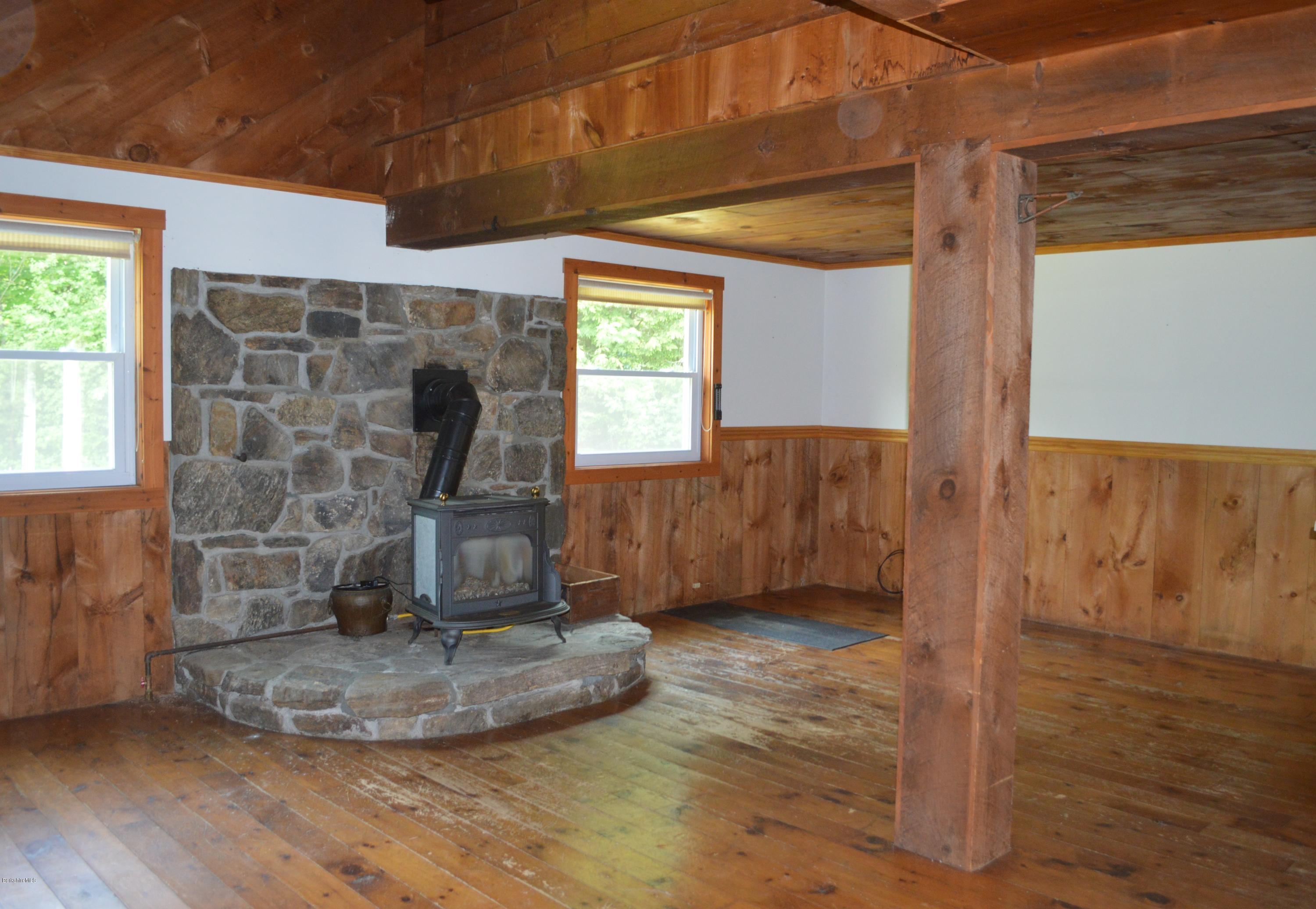 115 Webster Road Tyringham, MA 01264 - Photo 5 of 23 a view of a livingroom with wooden floor and chair